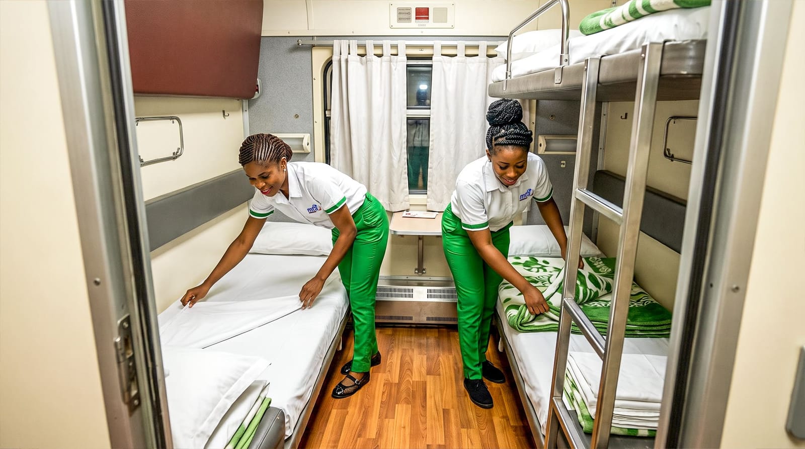 Hôtesses MTA Express préparant les couchettes d'une cabine de train